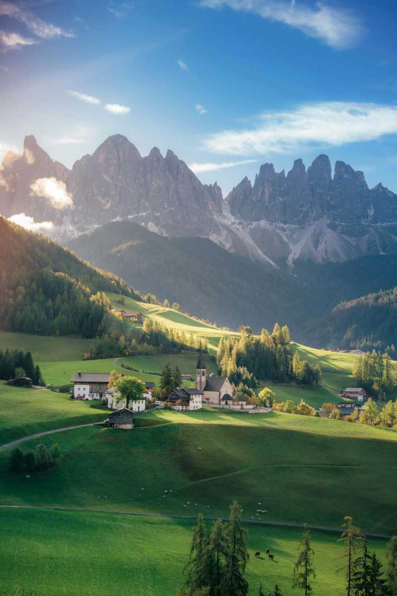 a green valley with mountains in the background 