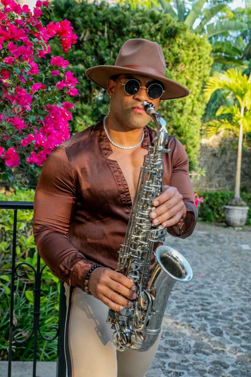 A man wearing hat playing saxophone