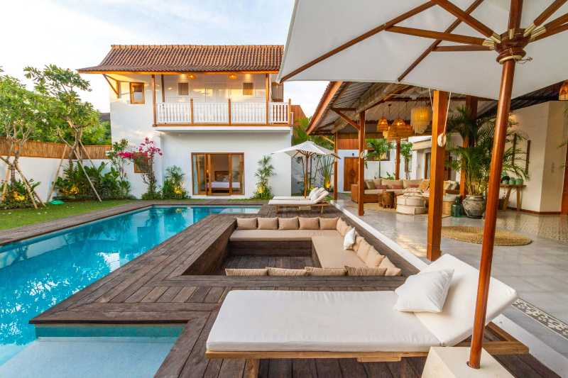 Sonnenliegen und eine Couch in der Nähe des Swimmingpools
