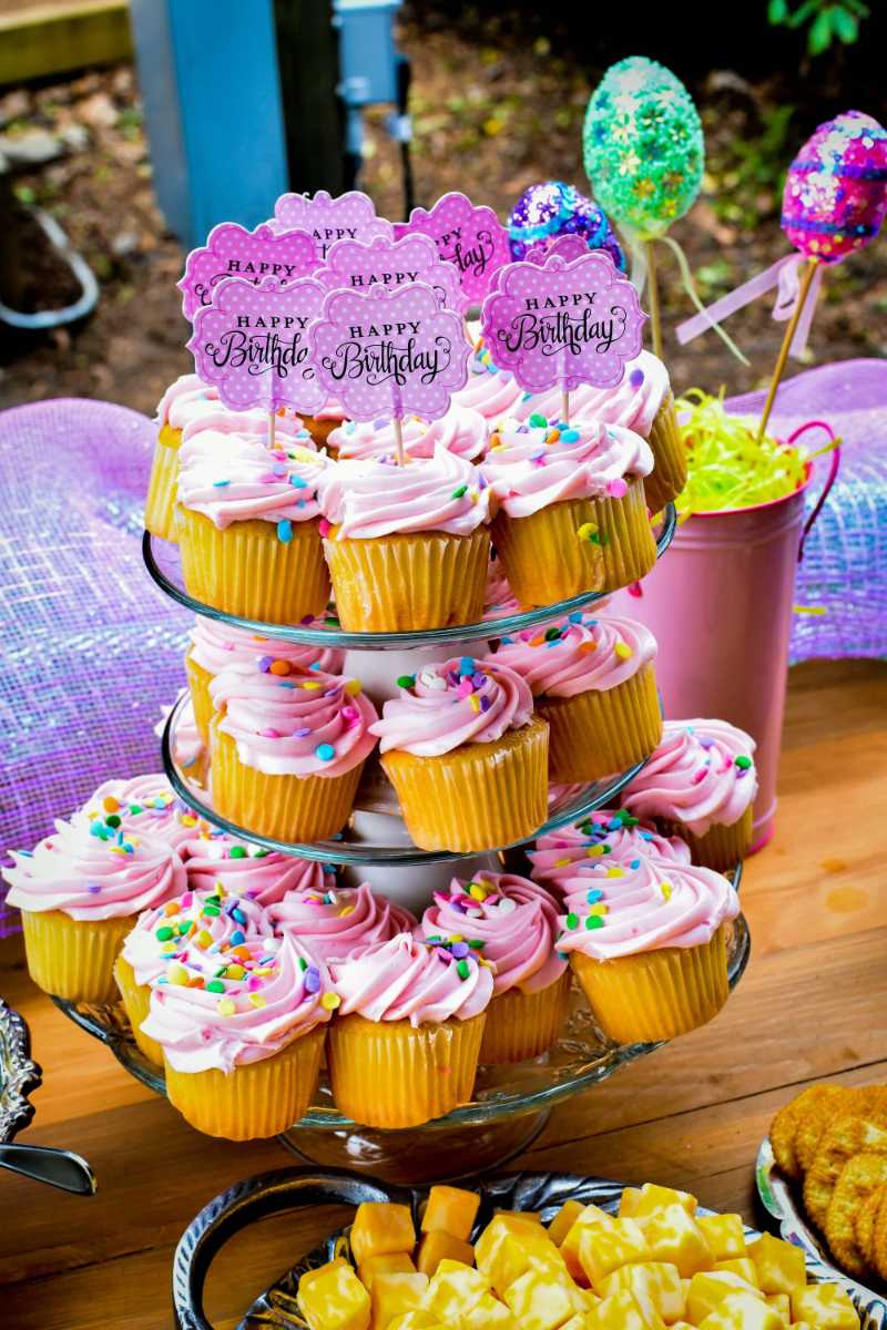 a table topped with lots of cupcakes covered in pink frosting - jigsaw puzzle