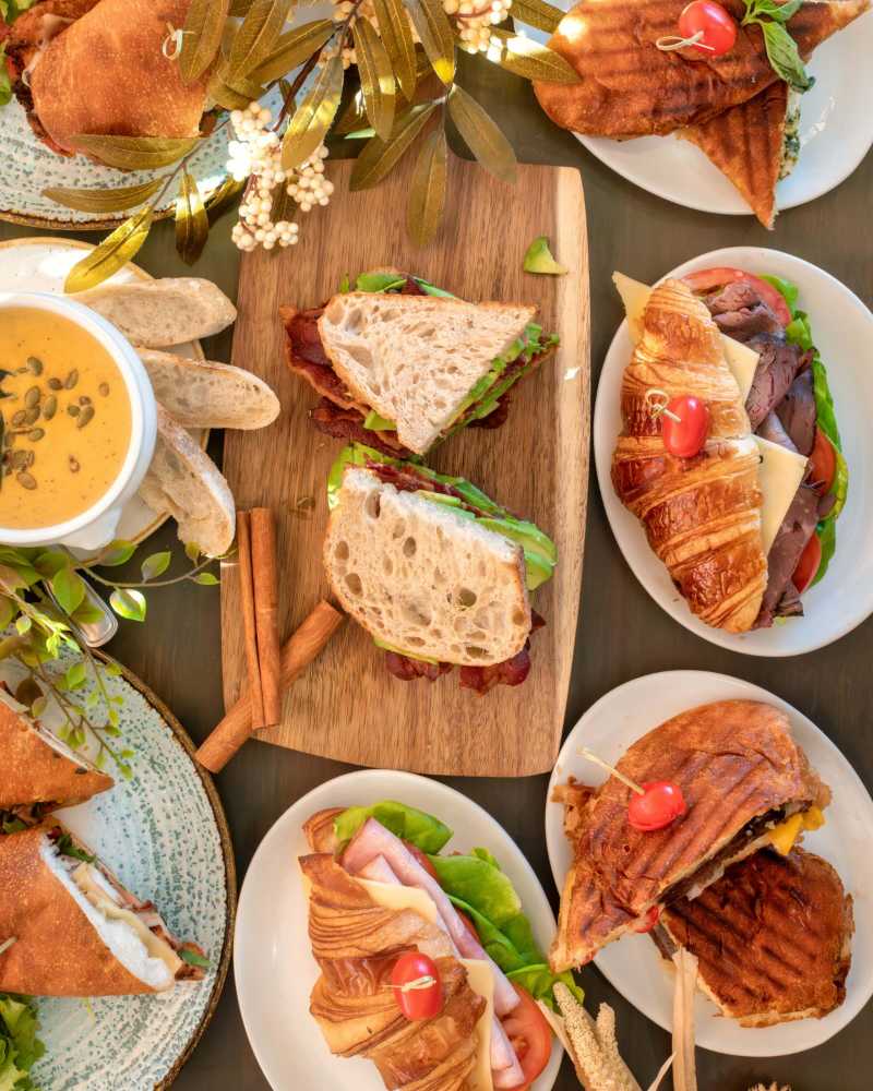 a table topped with plates filled with sandwiches - jigsaw puzzle