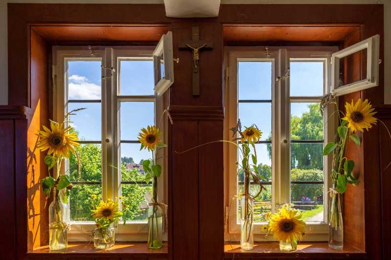 a window in the dining room with rural flower decorations