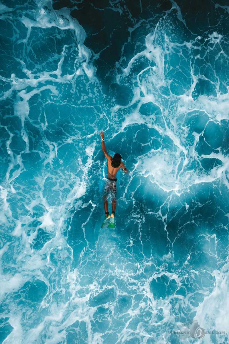Aerial View of Surfer on Azure Waves in Maldives