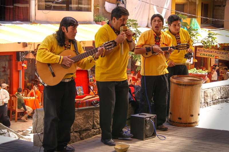 Andean musicians performing with traditional instruments on a street in Cusco Peru