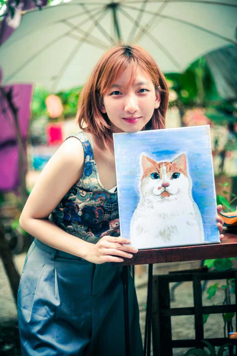Artista sosteniendo un retrato de gato