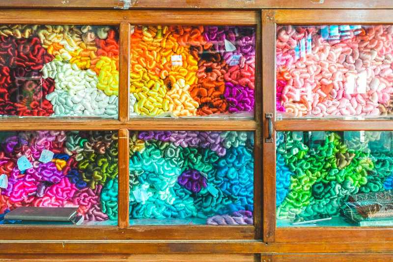 assorted color textiles in brown wooden cabinet