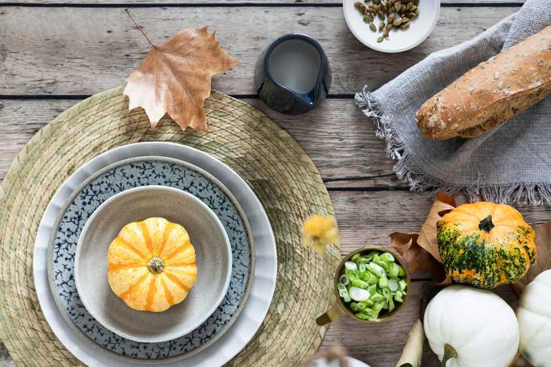 Autumn Thanksgiving table setting with pumpkins and rustic decor