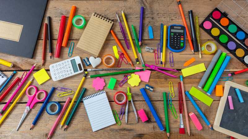 Útiles escolares para el regreso a clases sobre fondo de madera vista superior