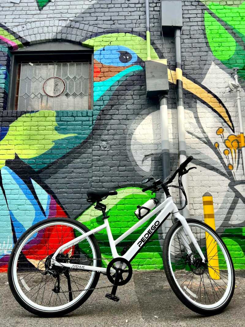 Bicycle parked in front of graffiti wall