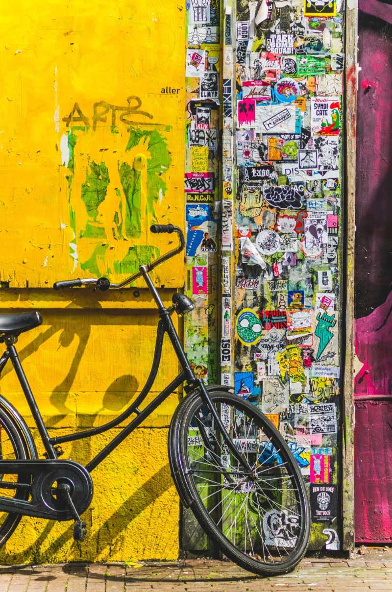 bike parked beside wall full of stickers - jigsaw puzzle