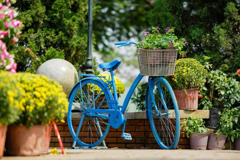 blaues Fahrrad mit Blumen in einem Korb