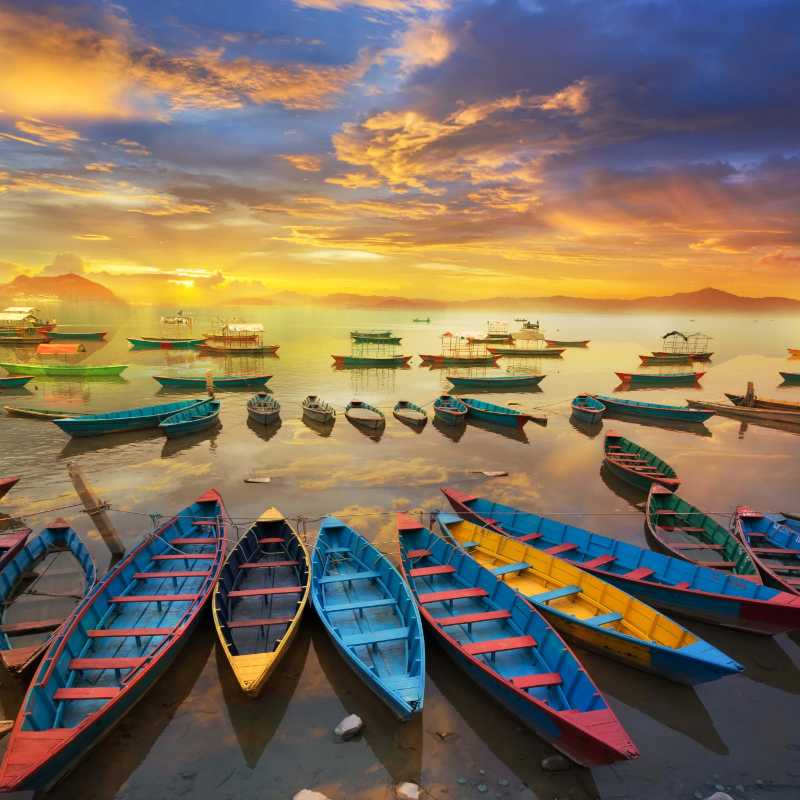 Barcos atracados no mar contra céu nublado durante o pôr do sol
