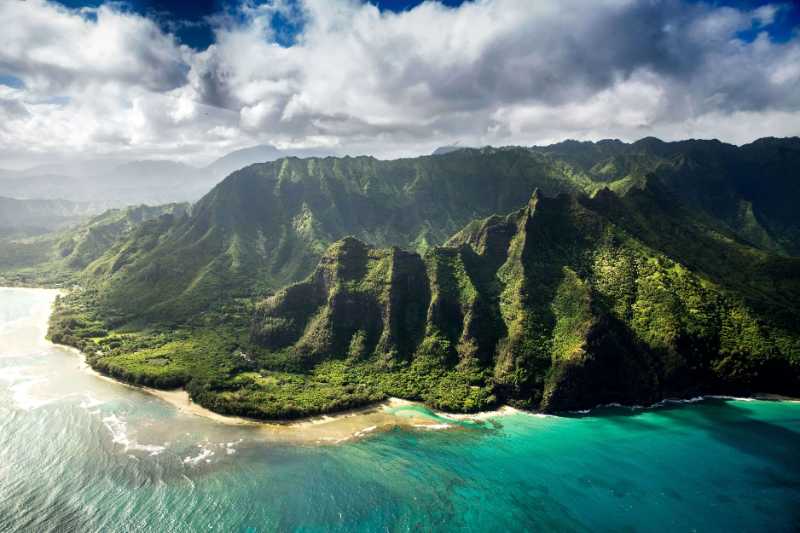 aerial photography of green mountain beside body of water under white sky - jigsaw puzzle