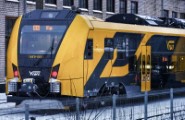 a yellow and black train parked next to a building - jigsaw puzzle