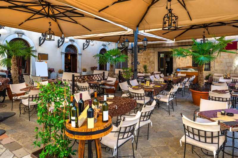 Mesas de café na rua aconchegante da cidade velha de Kotor Montenegro