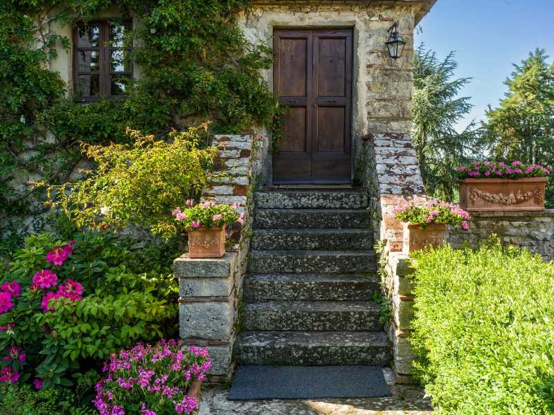 Charmanter rustikaler Eingang zum Steinhaus mit Blumen