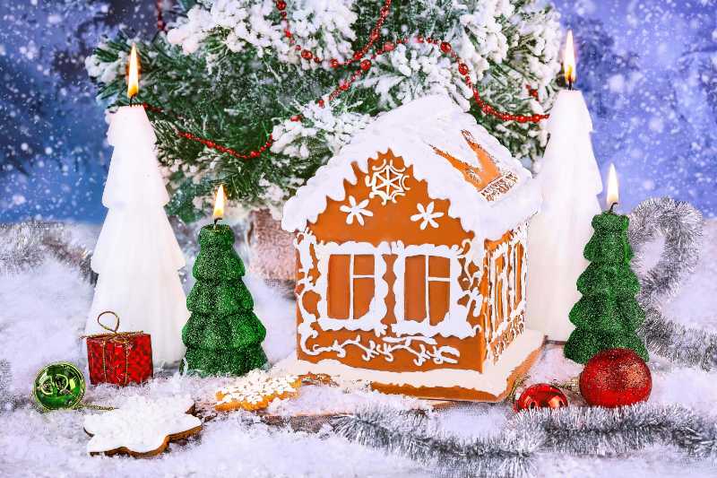 Christmas gingerbread house and gingerbread cookies on a snowy background