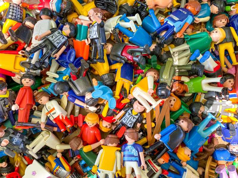 Primer plano de una pila de figuras de plástico de colores y muñecos de juguete