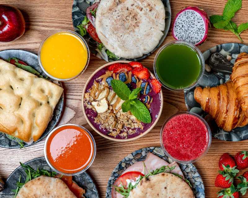 colorful breakfast spread with smoothies and pastries