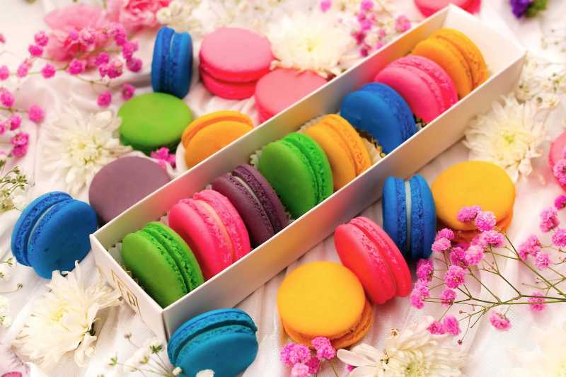 Bunte Macarons mit Blumenarrangement