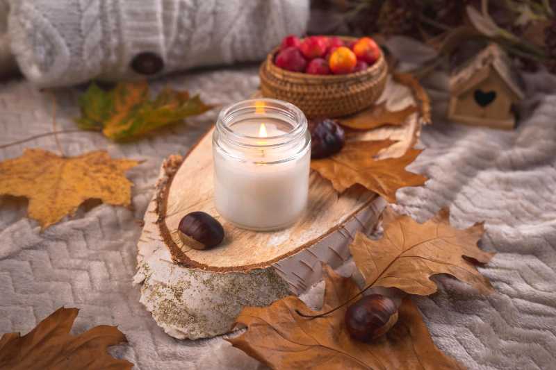 cozy autumn still life with candle and leaves