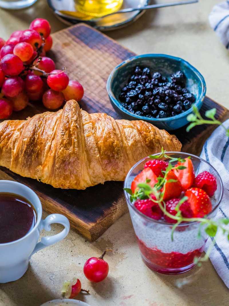 Croissant Bread with Strawberries Raspberries and Blueberries on a wooden tray