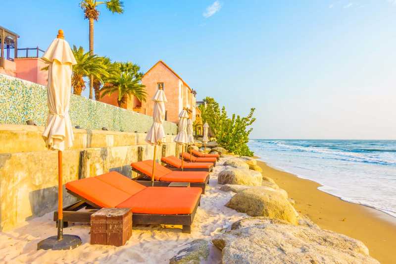 Sedie a sdraio sulla spiaggia e splendido tramonto