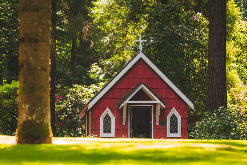 red chapel on grassy field with trees - jigsaw puzzle