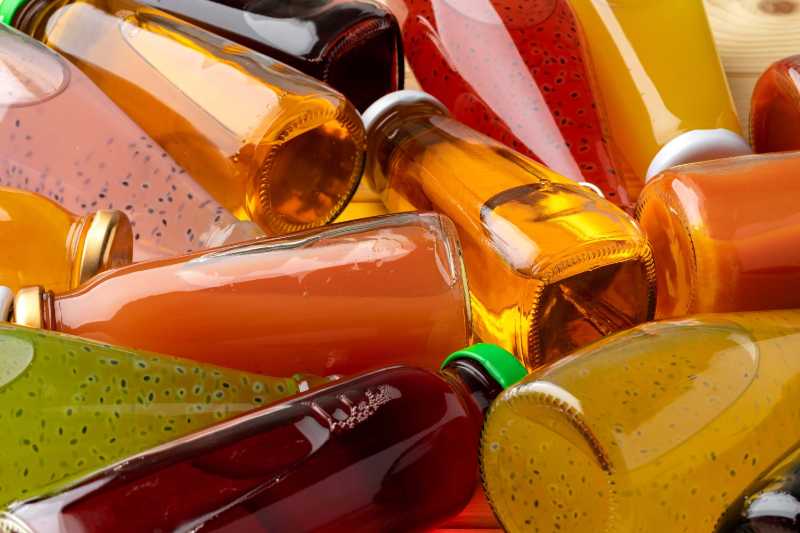 Verschiedene Flaschen Saft auf Holztisch