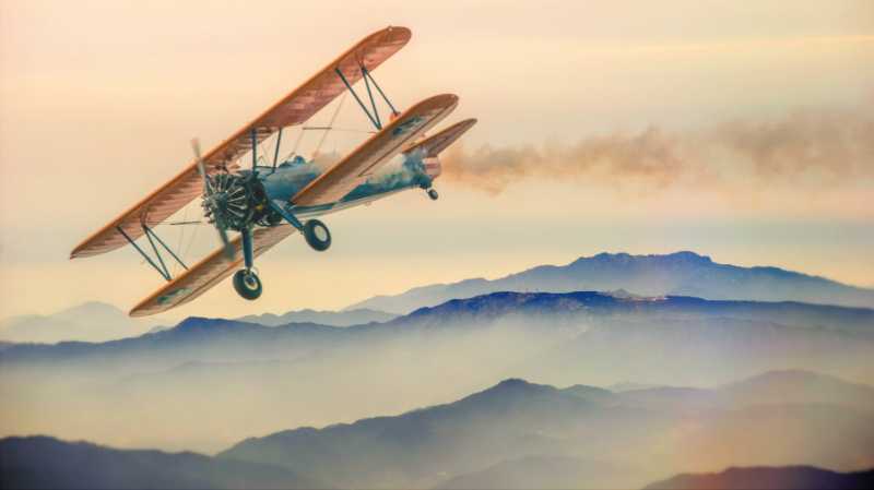 Vintage Biplane Flying Over Mountains Adventure and Travel