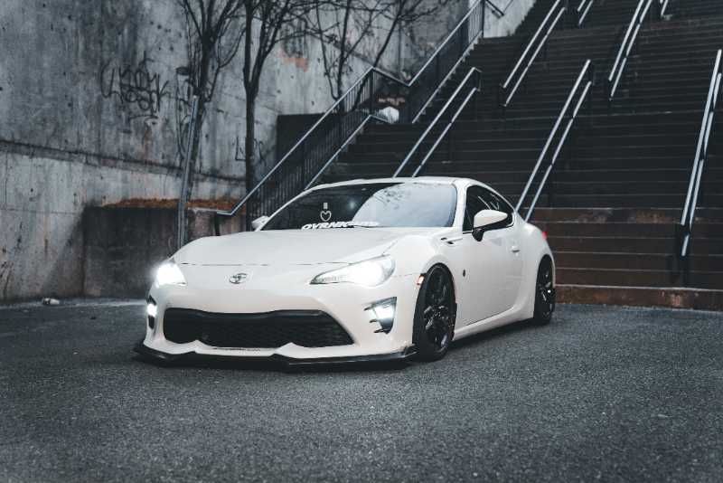 a white sports car parked in front of a set of stairs - jigsaw puzzle