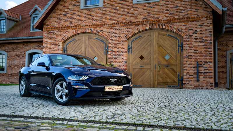 Ford Mustang garée à côté d'un bâtiment en briques brunes