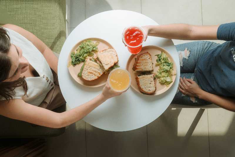 a man and a woman sitting at a table with a plate of food - jigsaw puzzle