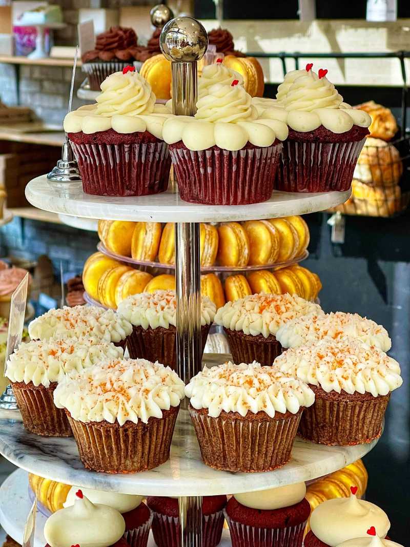 Exhibición de panadería gourmet con cupcakes glaseados
