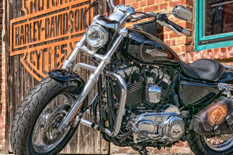 Motocicleta Harley Davidson estacionada contra una pared de ladrillos