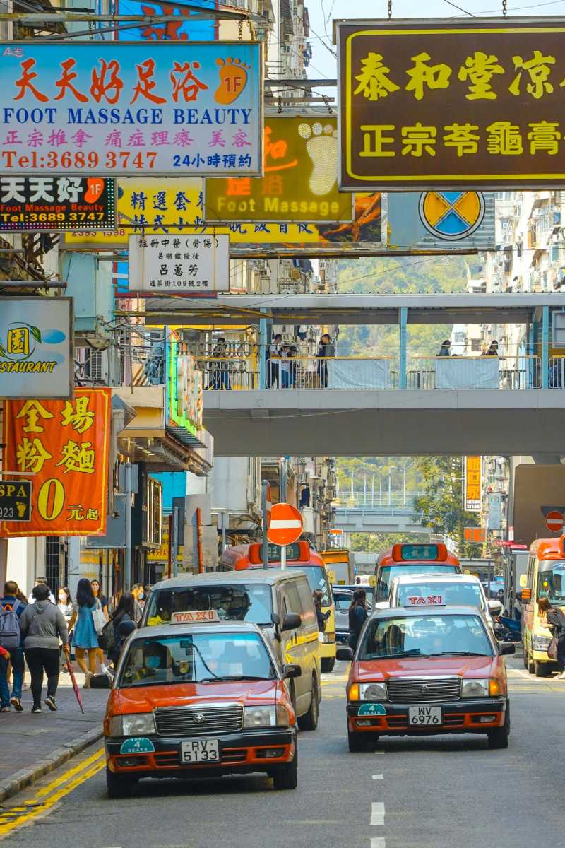 Hong Kong Street Scene with Red Taxis and Neon Signs