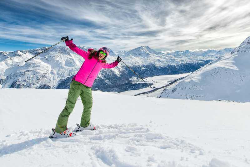 Joyful Woman Skiing on Sunny Snowy Mountain Peak