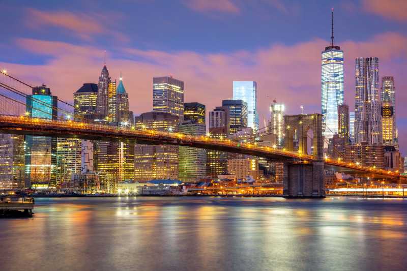 Manhattan skyscrapers and brooklyn bridge beautiful gentle colors of sky and city illuminations new york usa