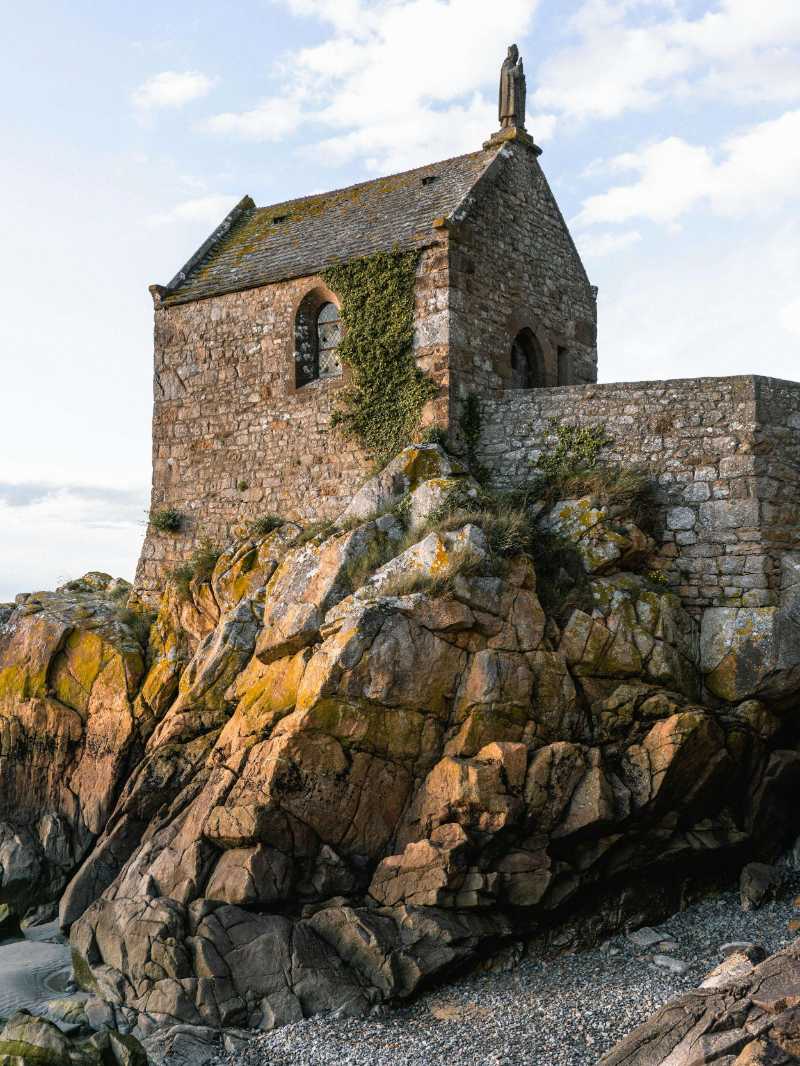 low angle photography of gray stone house on boulder - jigsaw puzzle