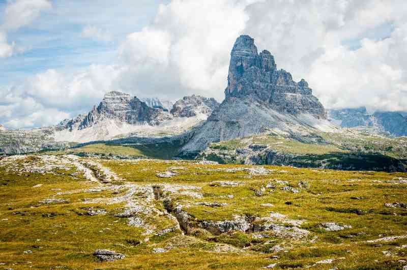 rock formation on wide field grass under cloudy blue sky during daytime - jigsaw puzzle