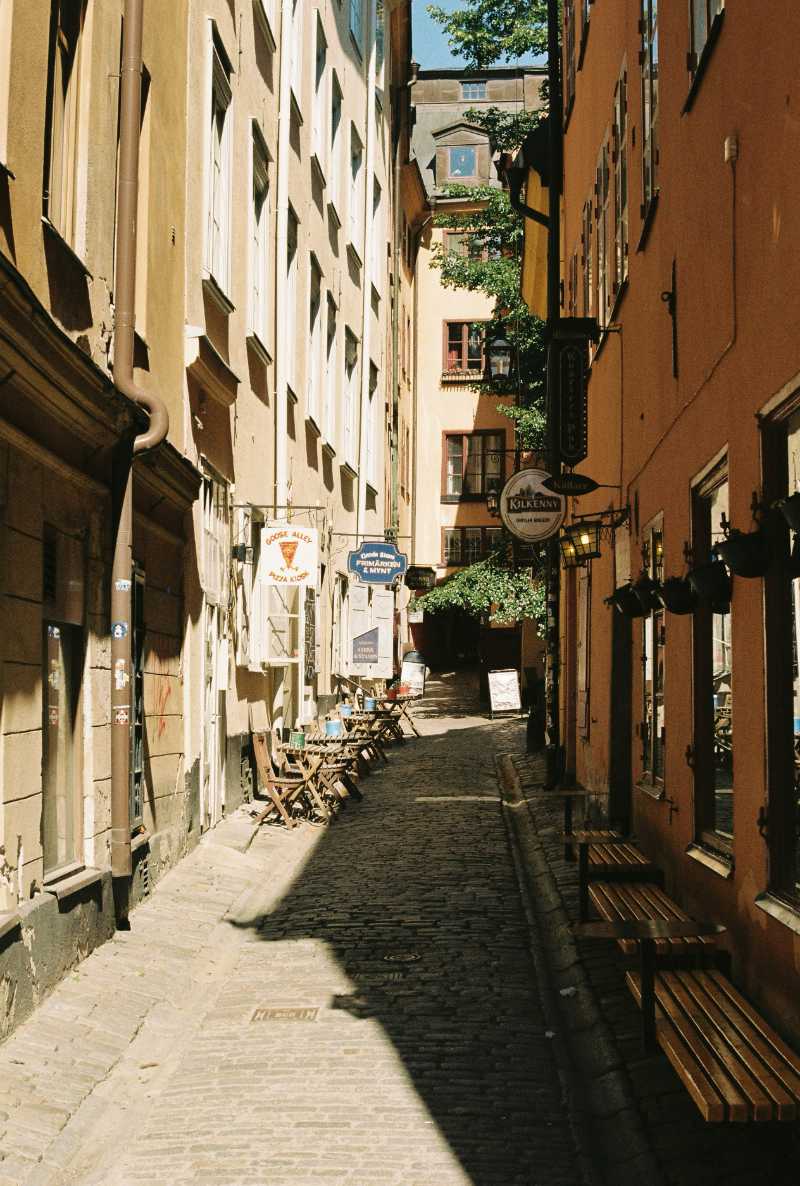 a narrow city street with benches on both sides - jigsaw puzzle