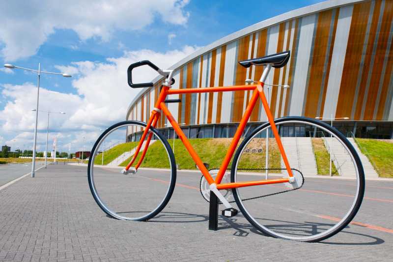 Orange bicycle outside sports stadium