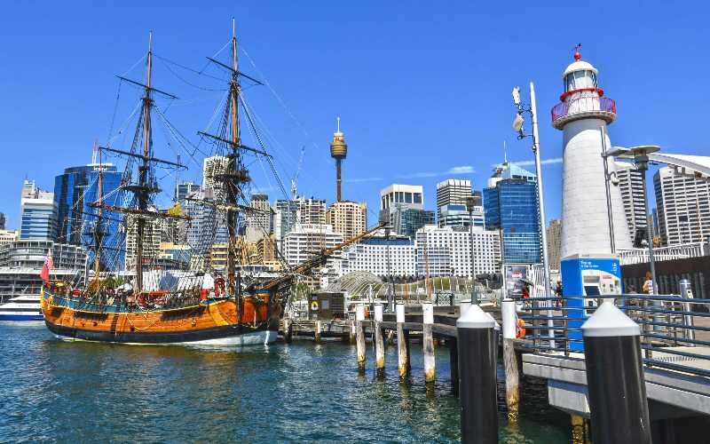 Orange Galleon Ship on Body of Water Beside City Buildings