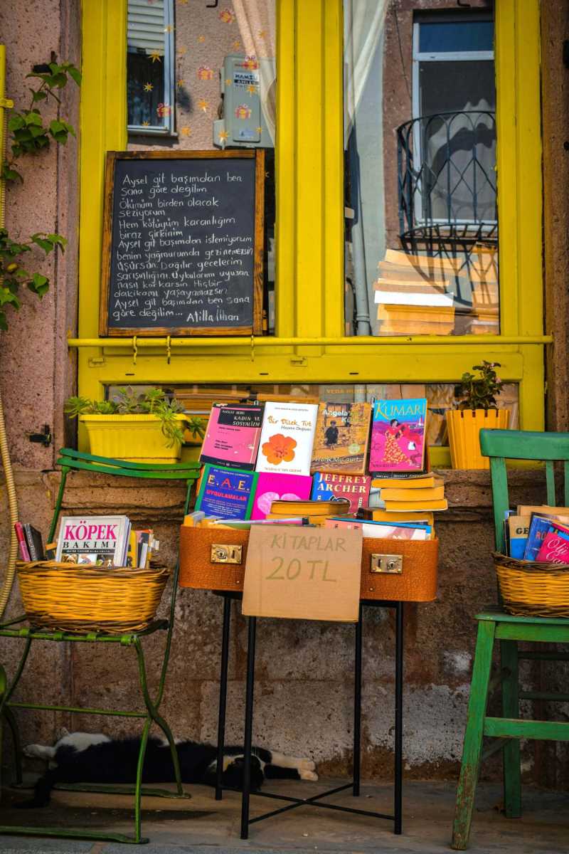 Outdoor Pop-up Bookstore Display with Bright Yellow Window and Suitcase