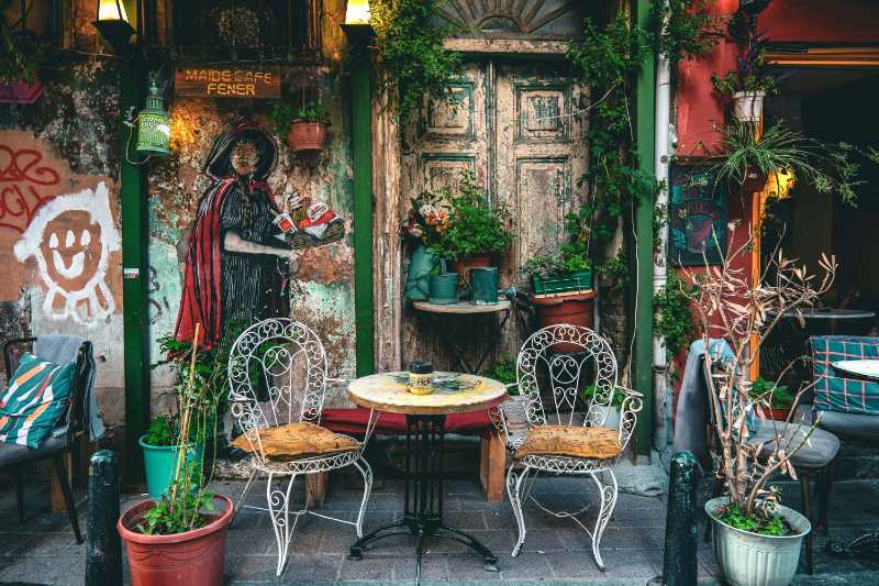 Terrasse des Cafés mit Wandgemälde und Topfpflanzen