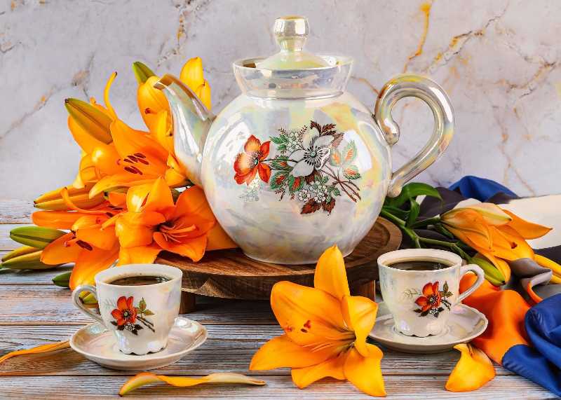 Pearl luster teapot and espresso cups surrounded by vibrant orange lilies