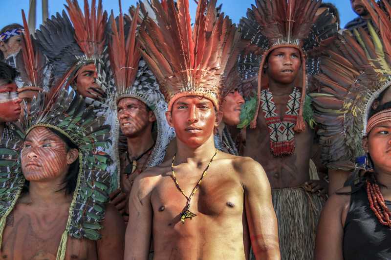 Portrait of Young Tribal Men with Red Feather Crowns and Ceremonial Dress