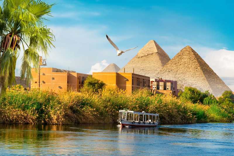 Pyramids View from Nile River Bank with Tour Boat