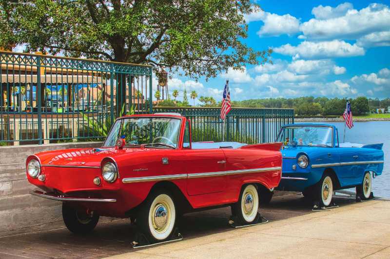 Red and blue vintage cars parked on roadside