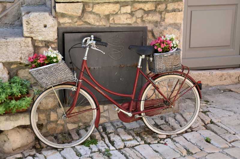 Rotes Fahrrad mit Körben und Blumen